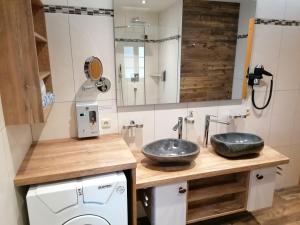 a bathroom with two sinks and a washing machine at Ferienhaus Veider in Obertilliach