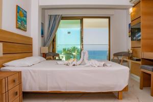 a bedroom with a bed with a view of the ocean at Rododafni Beach Apartments in Paphos City +99 photos