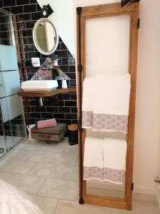 een badkamer met een handdoekenrek en een spiegel bij Chambre d'hôte Margot'te in Mimizan