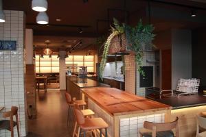 a kitchen with a wooden counter and chairs in it at CVJM Jugendhotel München in Munich