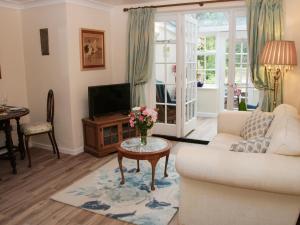 a living room with a couch and a tv at Troutbeck Cottage in Ludlow