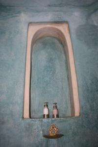 twee vazen op een plank onder een raam bij Riad Lorsya in Marrakesh