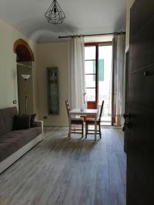 a living room with a couch and a table and chairs at Appartamento Il balcone in Prato