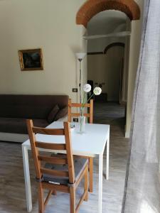 a white table with two chairs and a vase with flowers at Appartamento Il balcone in Prato