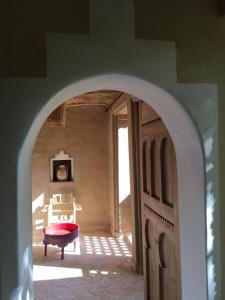 Dar Zahia في تارودانت: مسار يؤدي إلى غرفة مع كرسي احمر