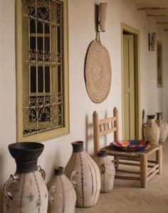 Dar Zahia في تارودانت: غرفة بها مجموعة من المزهريات ومقعد