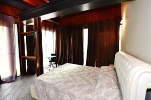 a bedroom with a white bed in a room with windows at La Terrazza sul Lago in Peschiera del Garda