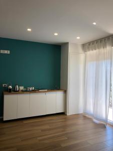 - une cuisine avec des placards blancs et un mur vert dans l'établissement SUITE ROOM TRANI, à Trani