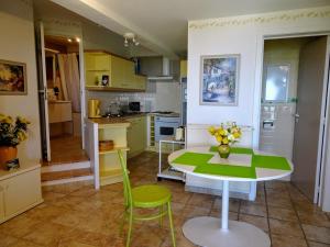 eine Küche mit einem Tisch, einem grünen Tisch und Stühlen in der Unterkunft Locaspera in Spéracèdes