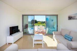 a living room with a couch and a tv at Millennium Golf Residences in Vilamoura