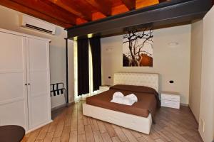 1 dormitorio con 1 cama y una pintura en la pared en La Terrazza sul Lago, en Peschiera del Garda