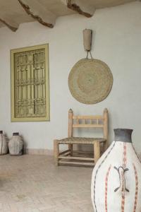 a room with a bench and a hat on the wall at Dar Zahia in Taroudant