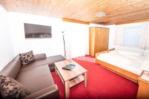Zimmer mit Sofa, Bett und Tisch in der Unterkunft Haus Bergkastelblick in Nauders