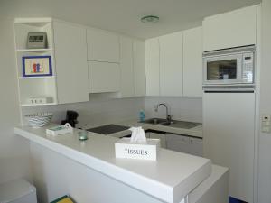 a kitchen with white cabinets and a box on a counter at LUXURY APP, frontal sea View + south terrace + garage in Middelkerke