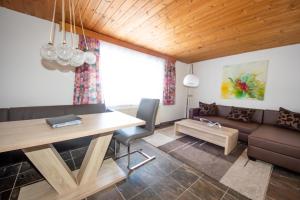 een woonkamer met een tafel en een bank bij Haus Bergkastelblick in Nauders