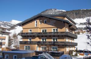ein großes Gebäude mit Balkon im Schnee in der Unterkunft Haus Bergkastelblick in Nauders