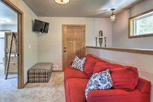 a living room with a red couch and a stool at Spacious Lakeside Family Home on Big Bearskin Lake in Hazelhurst