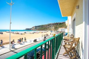 een balkon met mensen die op het strand lopen bij T3 Aleluia in Nazaré
