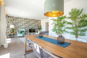 een eetkamer met een houten tafel en planten bij T3 Aleluia in Nazaré