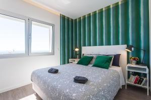een slaapkamer met een groot bed met groene muren bij T3 Aleluia in Nazaré