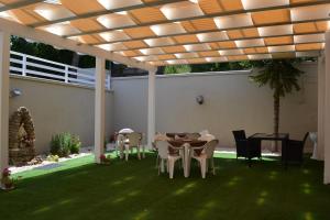 eine Terrasse mit Tisch und Stühlen unter einer Pergola in der Unterkunft Hotel Immagine in San Giovanni Rotondo