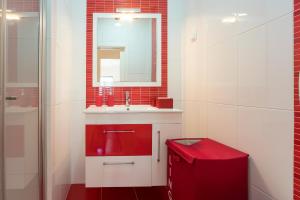 a bathroom with a red sink and a mirror at T3 Abegoarias Filipe do Canto in Nazaré