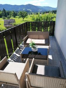 un patio con sedie e un tavolo sul balcone. di Apartments Novak a Ljubno