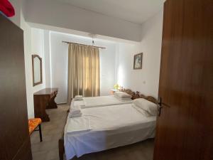 a bedroom with a white bed and a window at Blue Sky Apartments in Karpathos Town