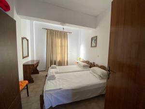 1 dormitorio con cama blanca y ventana en Blue Sky Apartments, en Karpathos