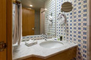 a bathroom with a sink and a mirror at Hotel Estoril Eden in Estoril
