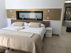 una camera con un grande letto e uno specchio di Fuertevillage a Costa Calma