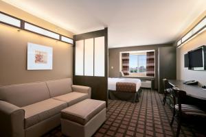 a hotel room with a couch and a bed and a desk at Microtel Inn & Suites in Sidney
