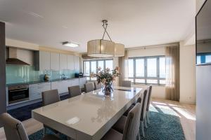 a kitchen and dining room with a table and chairs at T3 Foz Norte (AL) in Nazaré