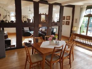 uma sala de estar com uma mesa de madeira e cadeiras em Ferienwohnung Stickereimuseum Oberhundem em Kirchhundem