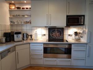 a kitchen with white cabinets and a stove top oven at Ferienwohnung Stickereimuseum Oberhundem in Kirchhundem