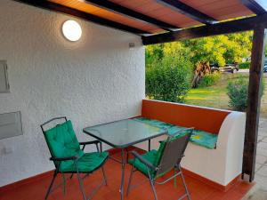 a table and chairs on a patio with a window at Studio Pedras d'el Rei in Santa Luzia
