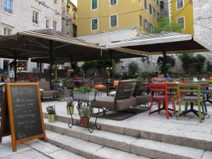 an outdoor patio with tables and chairs and umbrellas at Inspired by A.C. in Šibenik