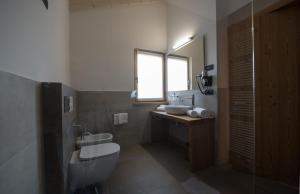 a bathroom with two sinks and a toilet and a window at Agritur Renetta in Tassullo