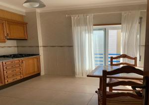 a kitchen with a dining table and a window at T1 Luminoso junto à Praia in Altura