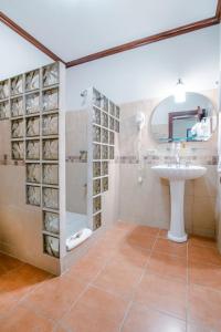 uma casa de banho com um lavatório e um chuveiro em Hotel Casa Roland Golfito Resort em Golfito