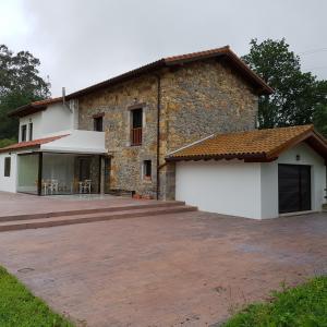 a house with a large patio in front of it at Posada las Albarcas in La Cavada