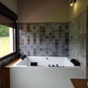 a bath tub in a bathroom with a tile wall at Posada las Albarcas in La Cavada +35 photos