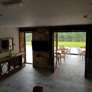 sala de estar con chimenea de piedra, mesa y sillas en Posada las Albarcas, en La Cavada