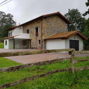 uma casa com uma cerca em frente em Posada las Albarcas em La Cavada