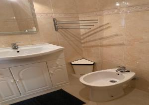 een badkamer met een witte wastafel en een toilet bij T1 Luminoso junto à Praia in Altura