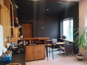 a kitchen with black walls and a table and chairs at The Monk's Bunk Kaunas in Kaunas