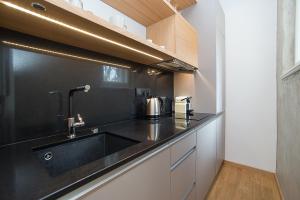 a kitchen with a sink and a black counter top at Charming apartment in famous area in Prague