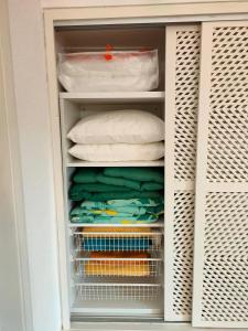 a closet filled with lots of towels and pillows at Studio Pedras d'el Rei in Santa Luzia