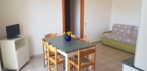 ein Esszimmer mit Tisch und Stühlen und einer Couch in der Unterkunft Appartamenti Rivabella Gallipoli in Rivabella