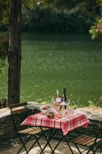 a picnic table with a red plaid table cloth and wine bottles at Ventozelo Hotel & Quinta in Ervedosa do Douro